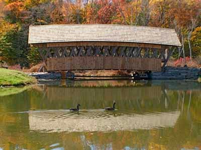 Gold Mine covered bridge spanning calm river in autumn