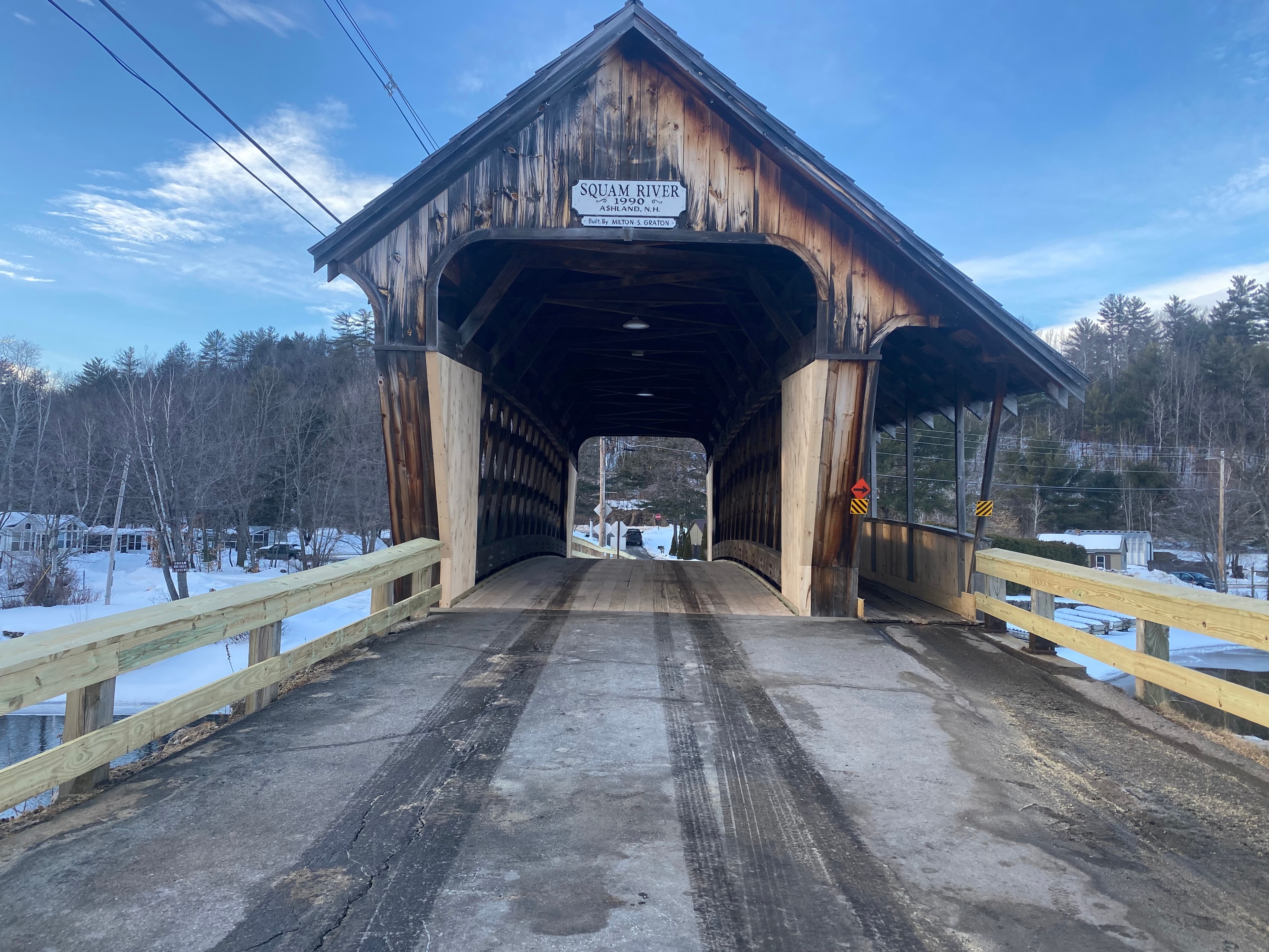 Squam River Bridge portal in winter with sign reading Squam River 1990 Ashland NH Built by Milton S. Graton