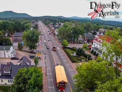 Aerial view of Stoney Morrill covered bridge being transported down main street through town