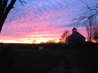 Dramatic pink and purple sunset sky with completed Coleman barn silhouette