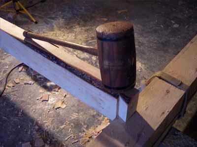 Wooden mallet resting on timber joint during Coleman barn construction